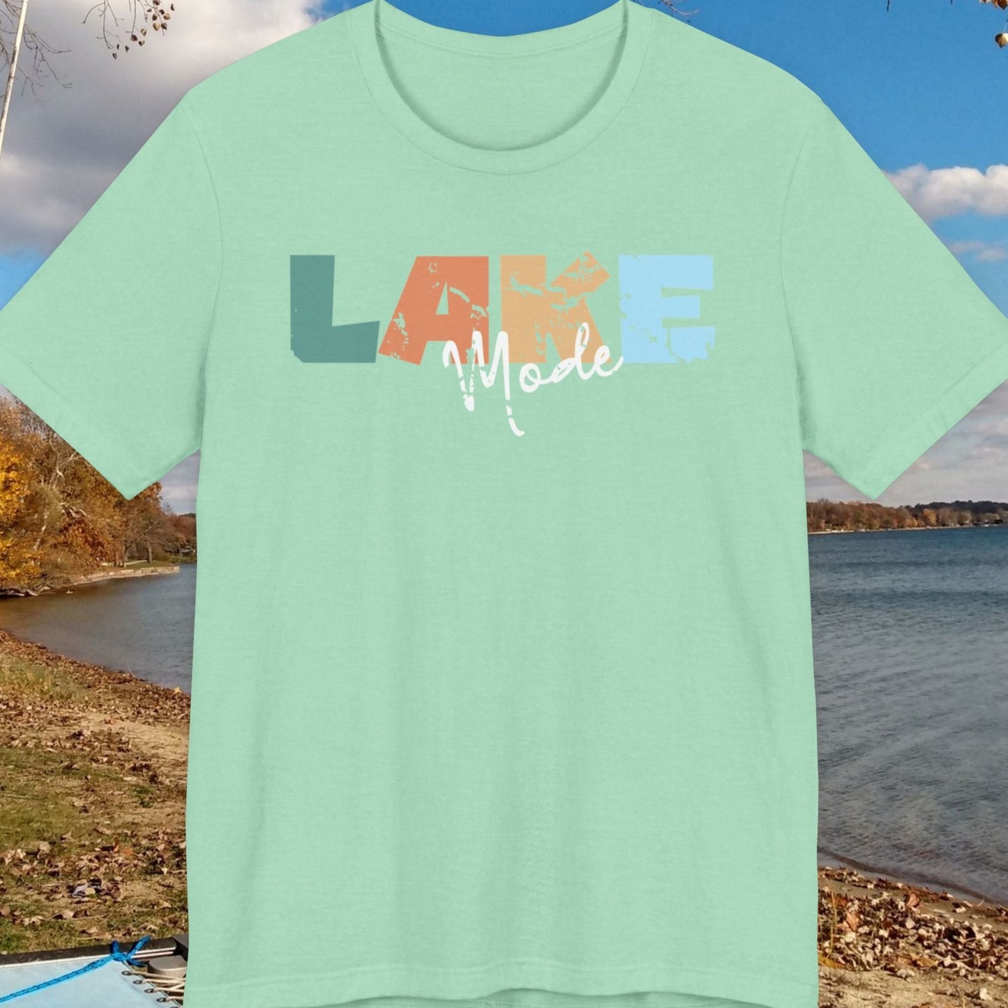 Mint green t-shirt with 'LAKE Mode' text on a lakeside background