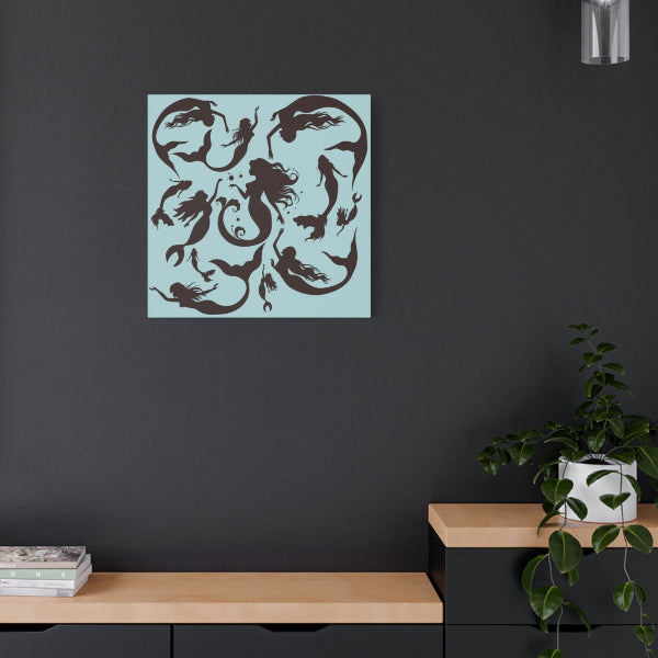 Square stretched canvas with sky blue background and printed with mermaid silhouettes.