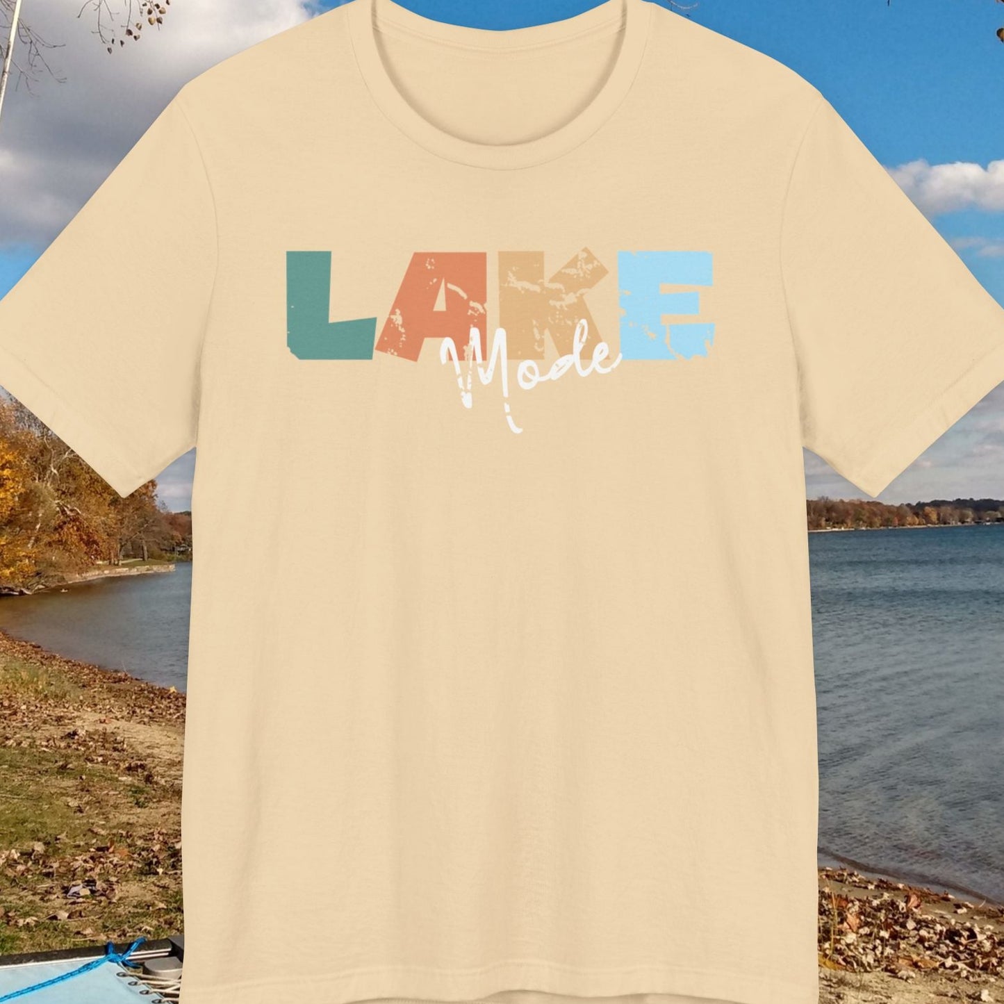 Beige t-shirt with 'LAKE Mode' text against a lakeside background