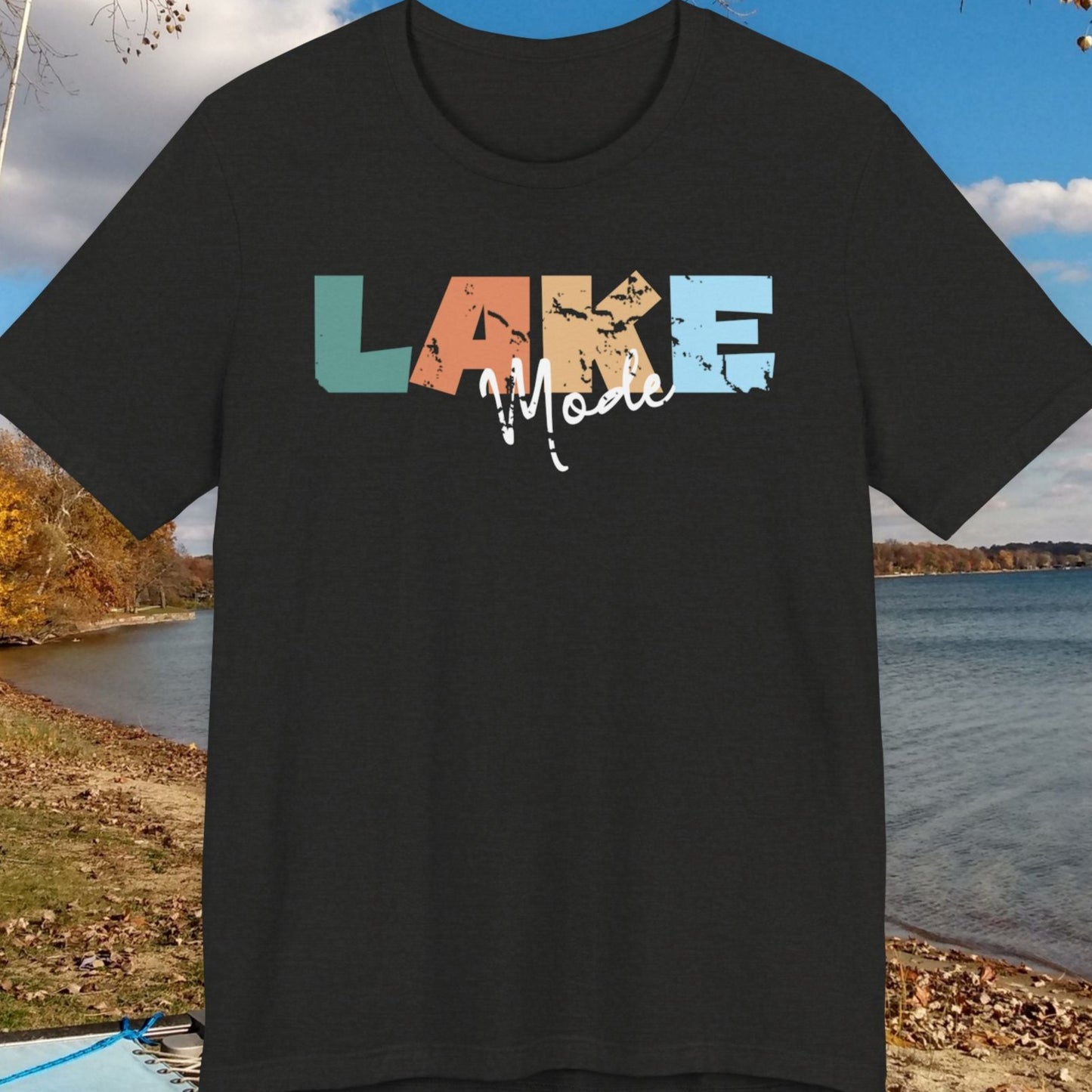 Black t-shirt with 'LAKE' text in colorful letters on a scenic lake background