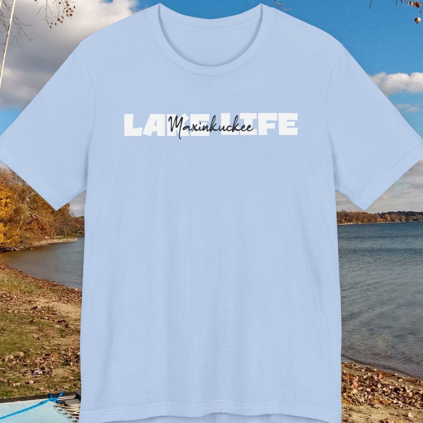 Light blue t-shirt with 'Lake Maxinkuckee' text against a scenic lake background
