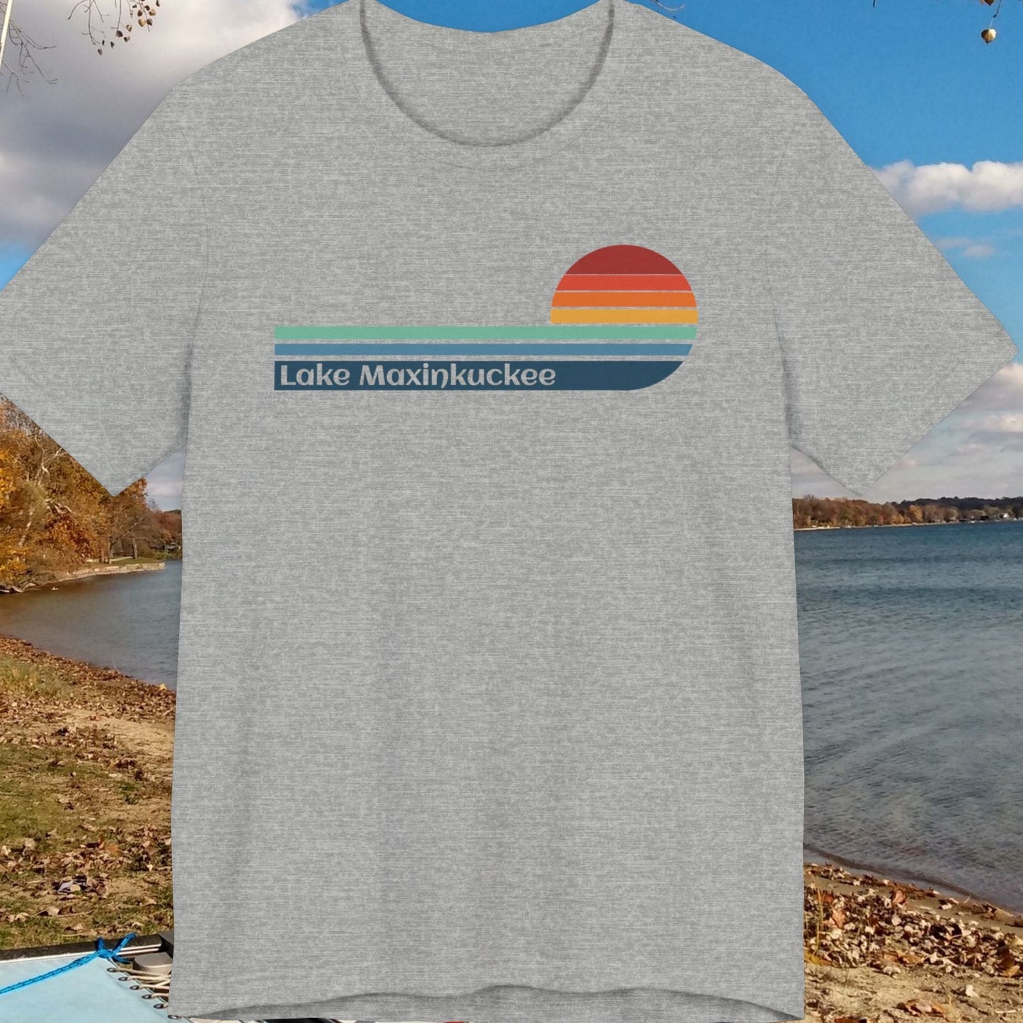 Gray t-shirt with 'Lake Maxinkuckee' design on a background of a lake and trees
