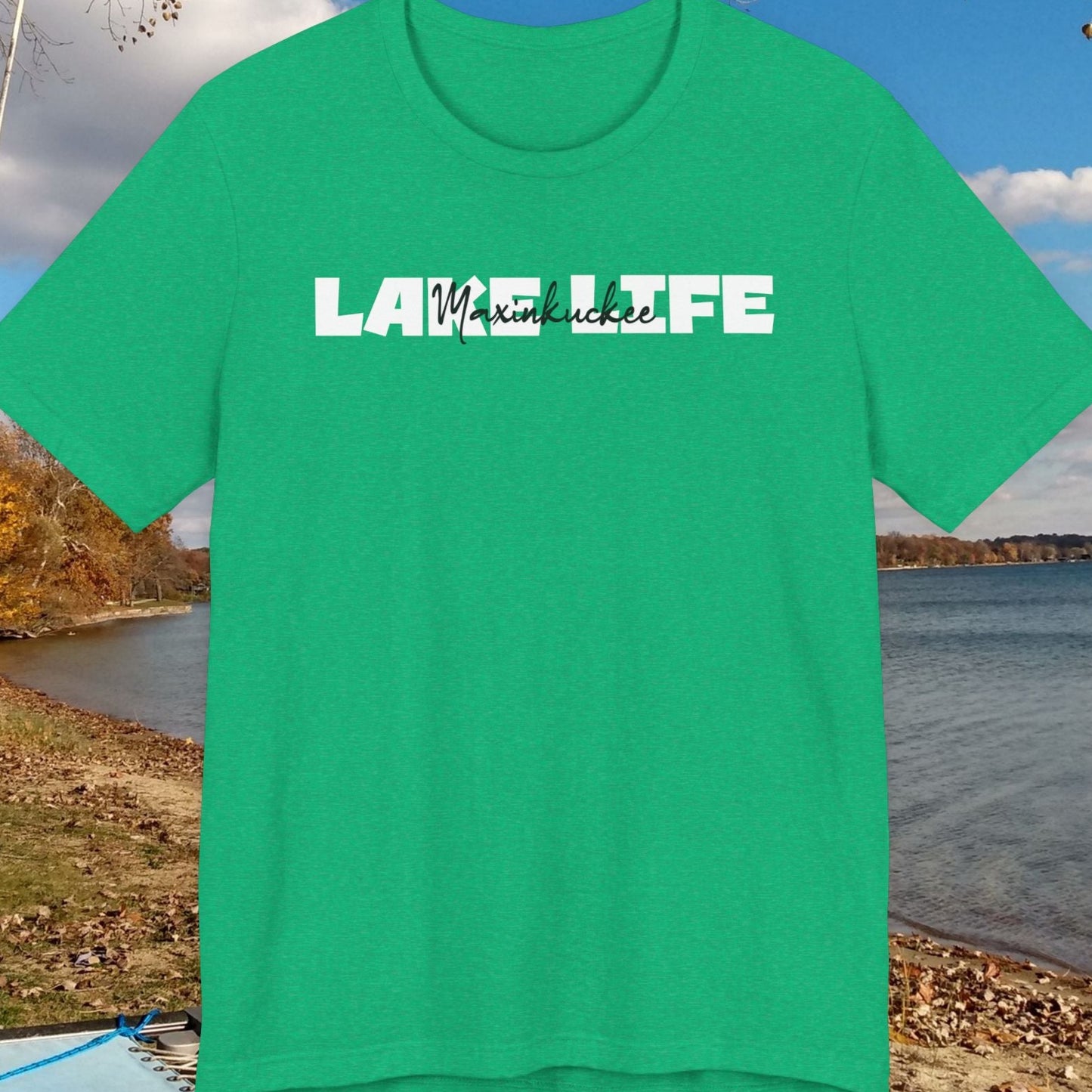 Green t-shirt with 'Lake Life' text on a scenic background of a lake and trees.