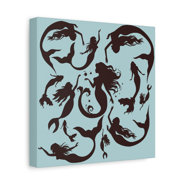 Square stretched canvas with sky blue background and printed with mermaid silhouettes.