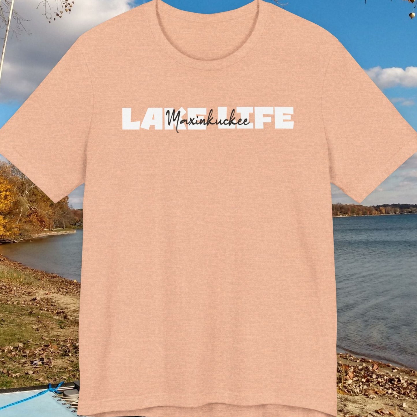 Beige t-shirt with 'Lake Life' text on a lakeside background