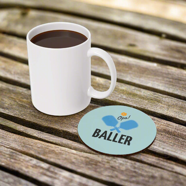 graphic of two pickleball paddles crossed with text OPA! above and BALLER underneath