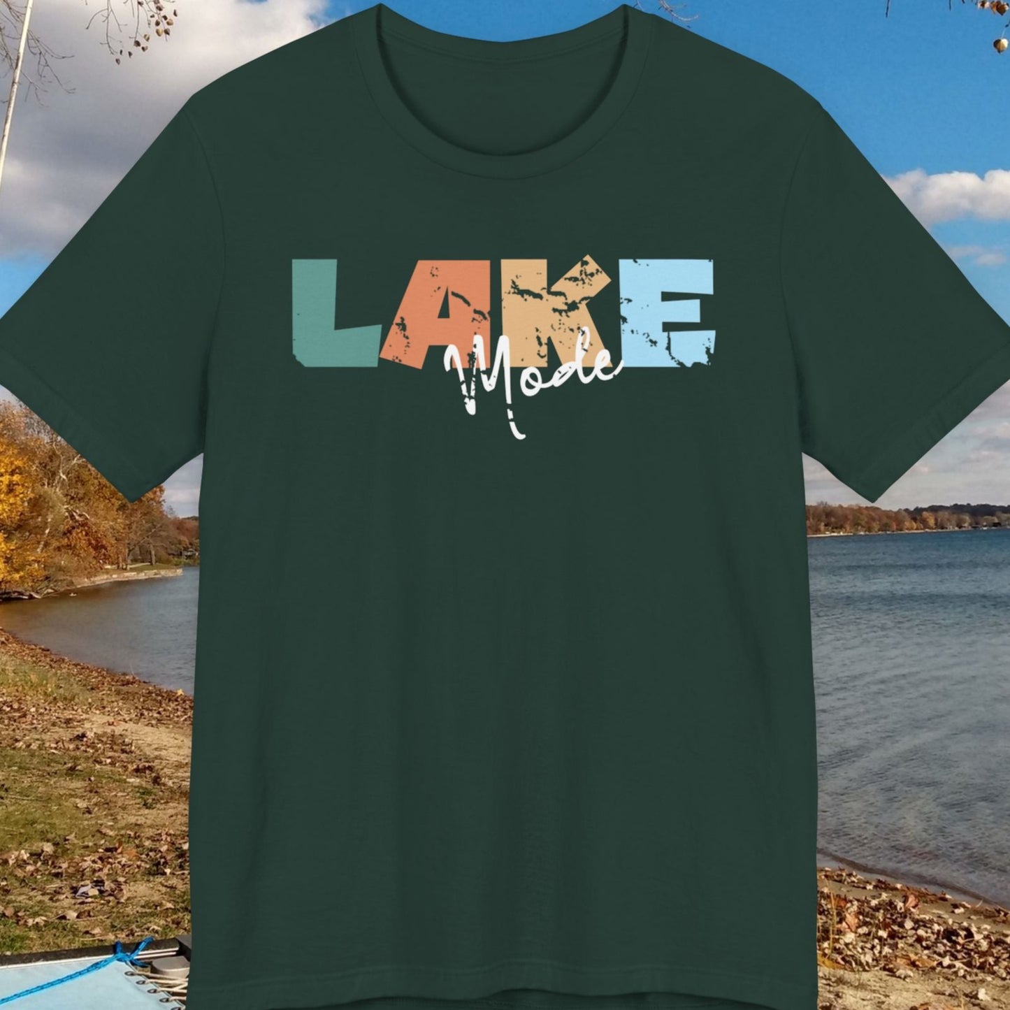 Green t-shirt with 'LAKE' design on a scenic lake background