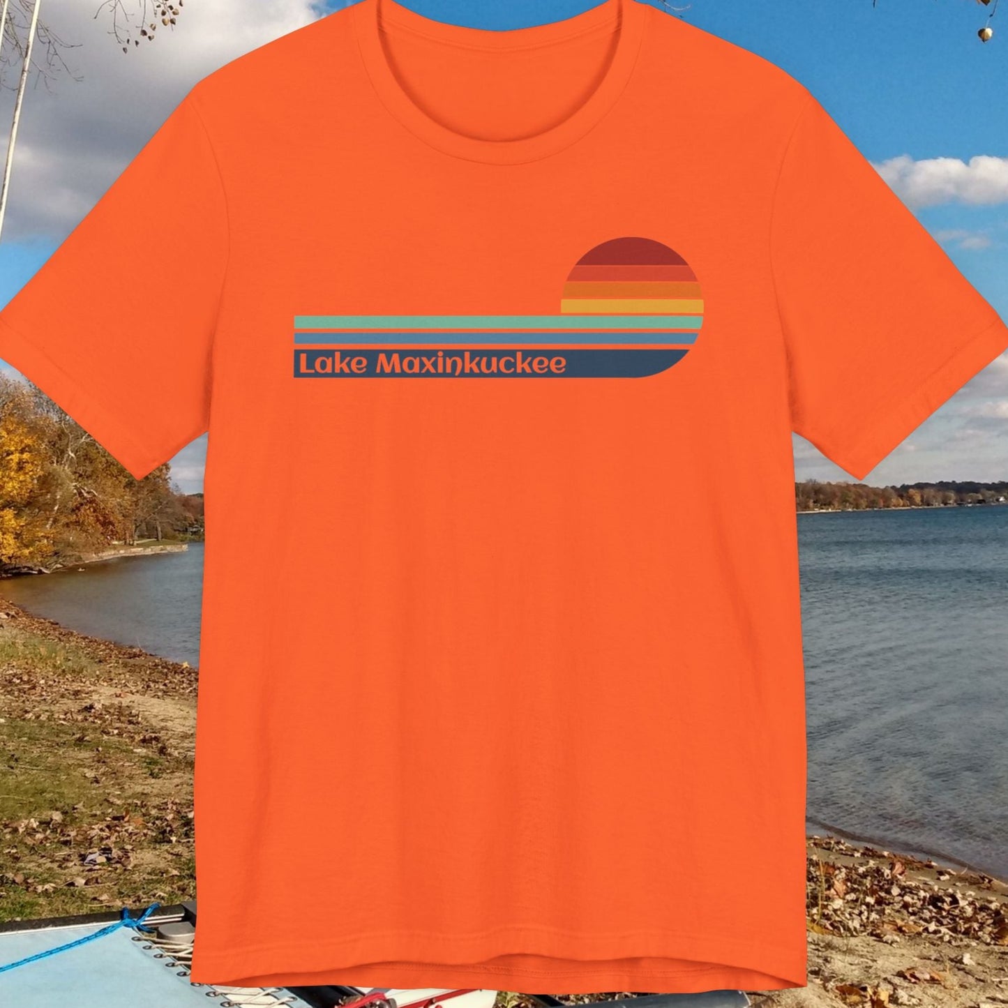 Orange t-shirt with 'Lake Maxinkuckee' design on a lakeside background