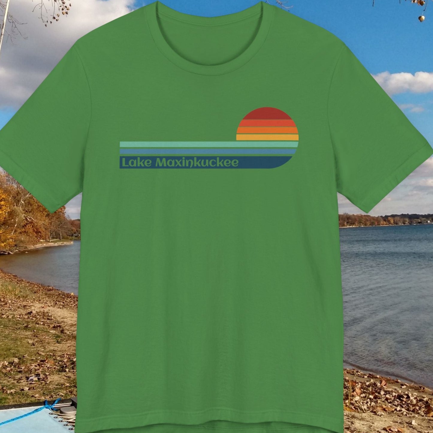 Green t-shirt with a colorful design on a lake and trees background