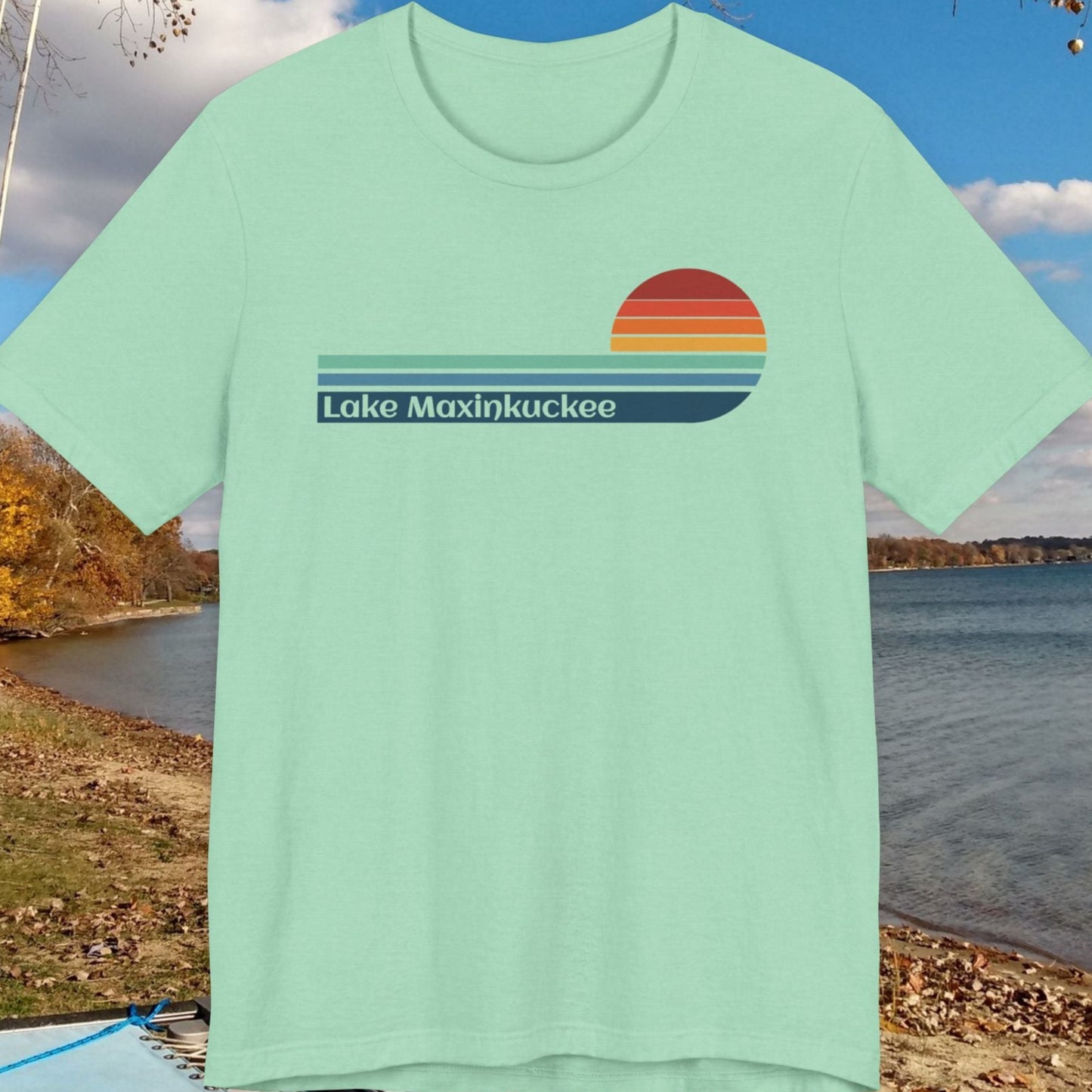 Mint green t-shirt with 'Lake Maxinkuckee' design on a lakeside background