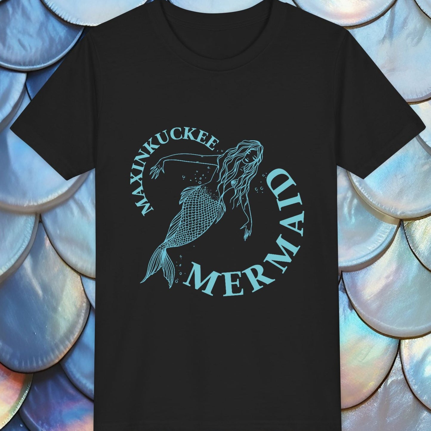 Black t-shirt with mermaid graphic and text on a background of blue and white shell-like patterns