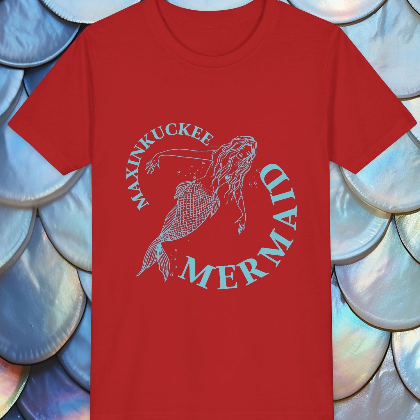 Red t-shirt with mermaid design and text on a background of blue and white scales.