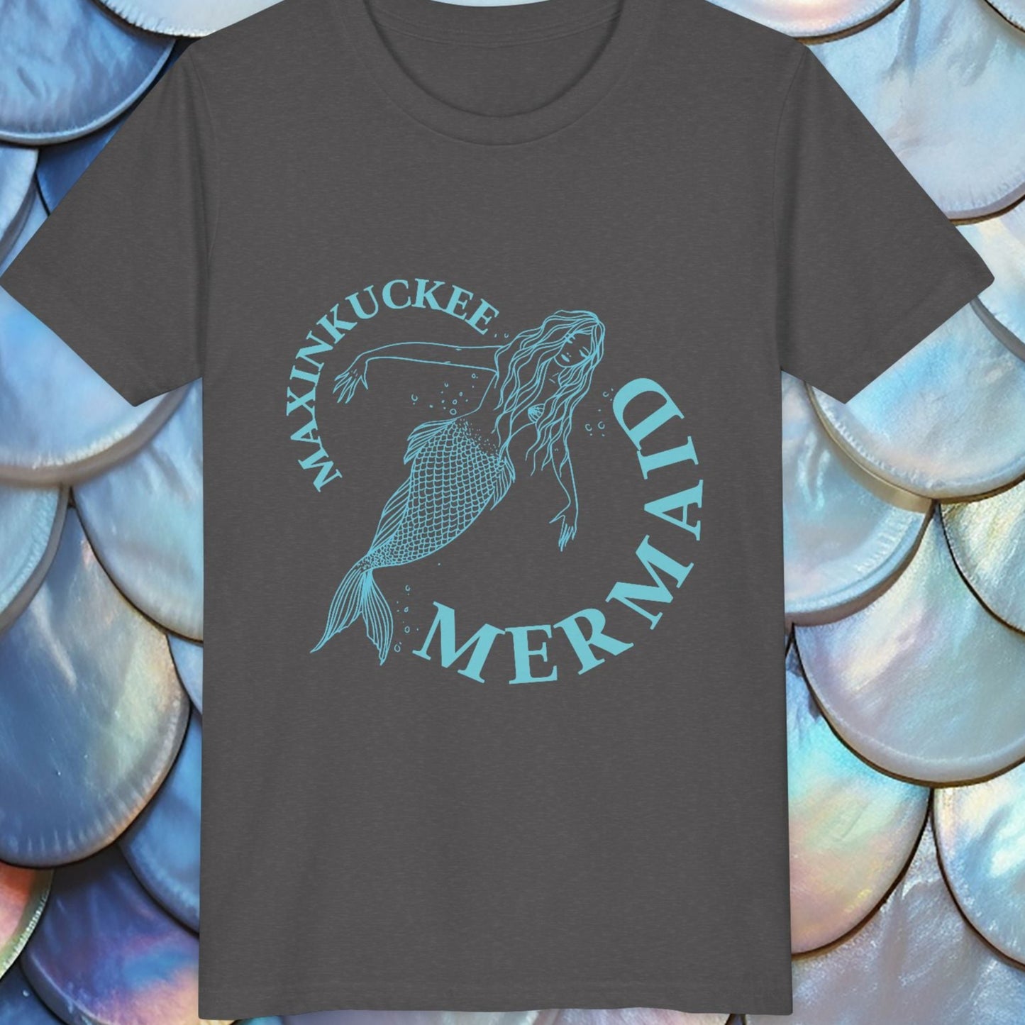 Dark gray t-shirt with 'Maxinkuckee Mermaid' design on a background of blue and white shell patterns.