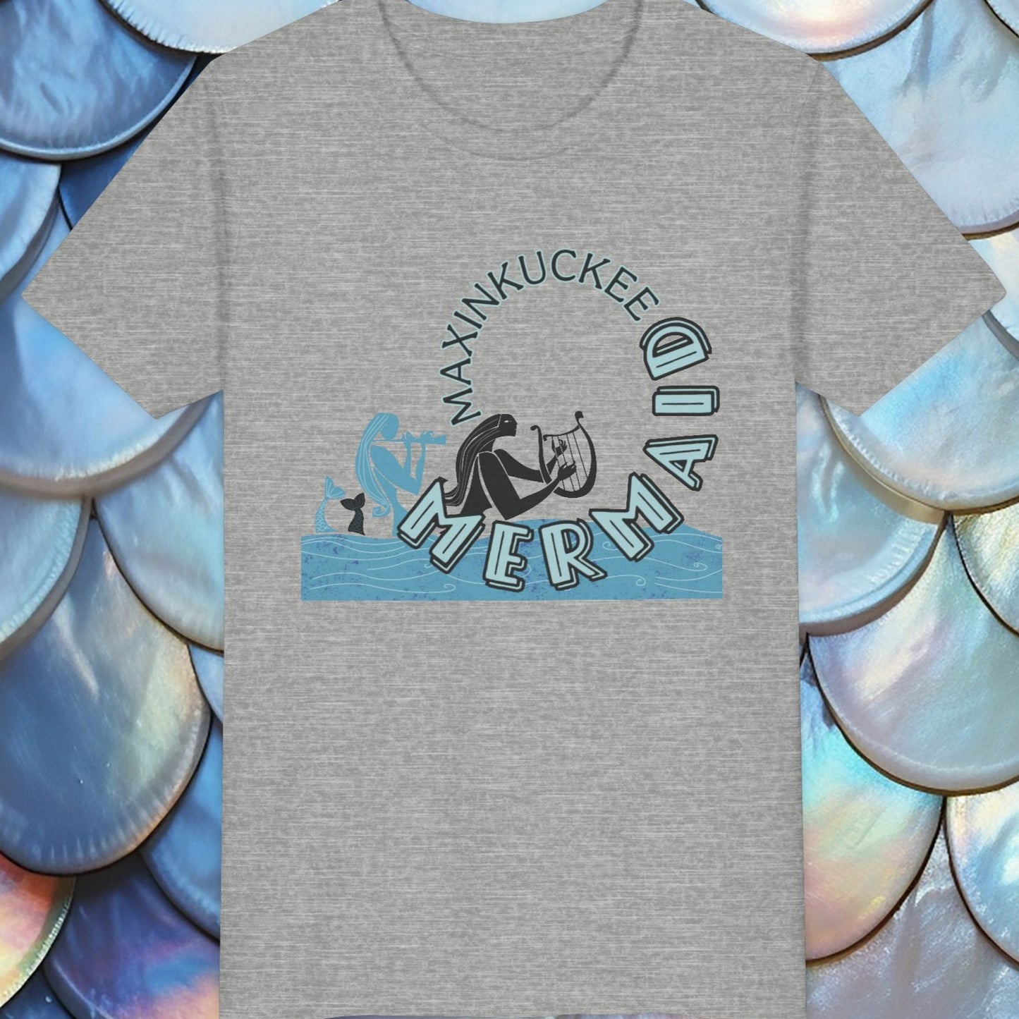 Gray t-shirt with 'Maxinkuckee Mermaid' design on a background of blue and white scales.