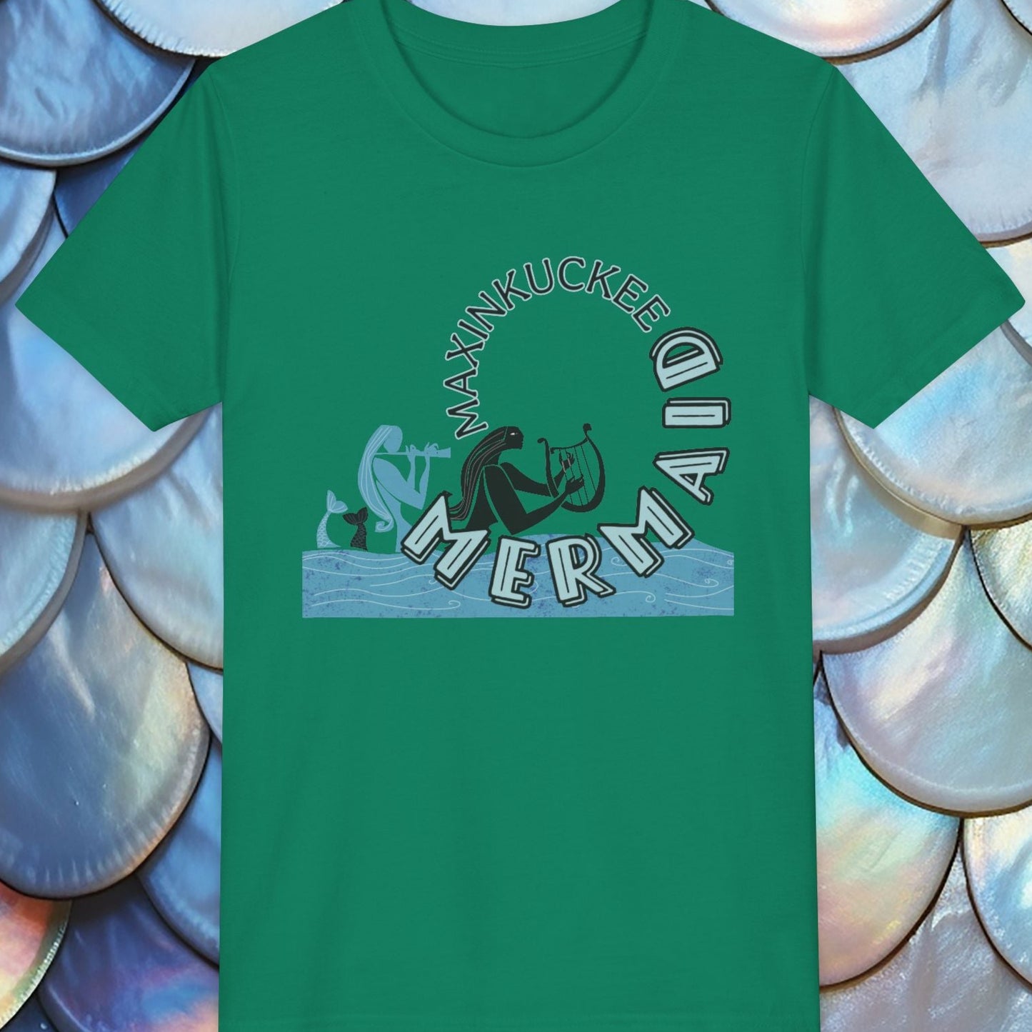Green t-shirt with mermaid graphic on a shell-patterned background