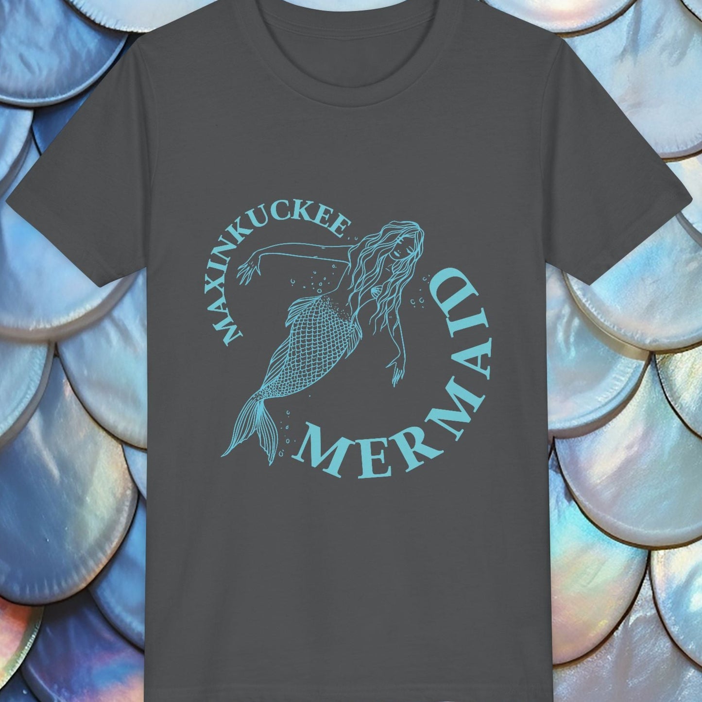 Dark gray t-shirt with 'Maxinkuckee Mermaid' design on a background of blue and white shell-like patterns.