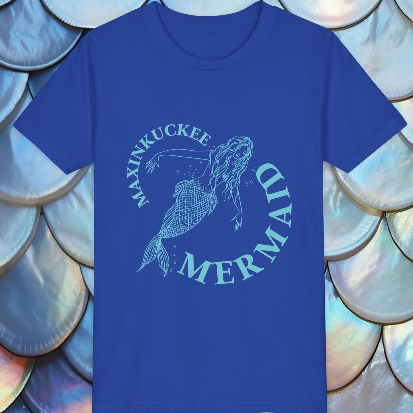 Blue t-shirt with mermaid design and text on a background of shell-like patterns