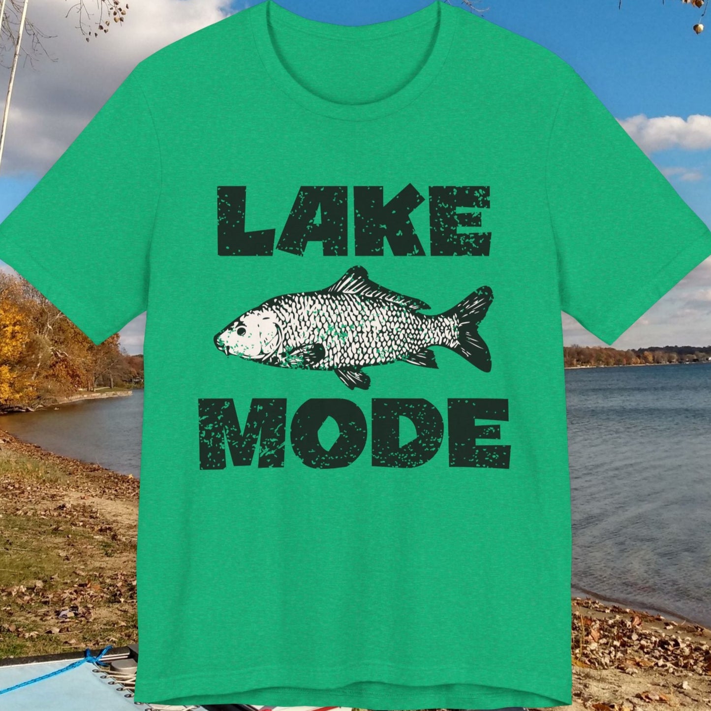 Green t-shirt with 'Lake Mode' and fish graphic in front of a lake