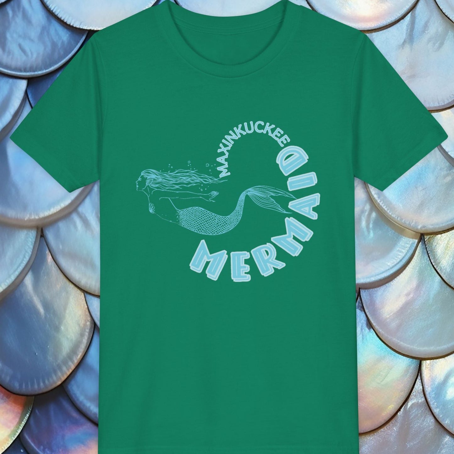 Green t-shirt with mermaid graphic and text on a shell-patterned background