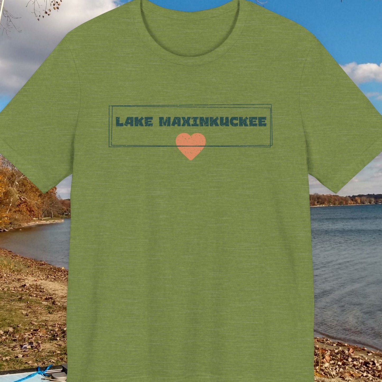 Green t-shirt with 'Lake Maxinkuckee' text and heart graphic on a lakeside background