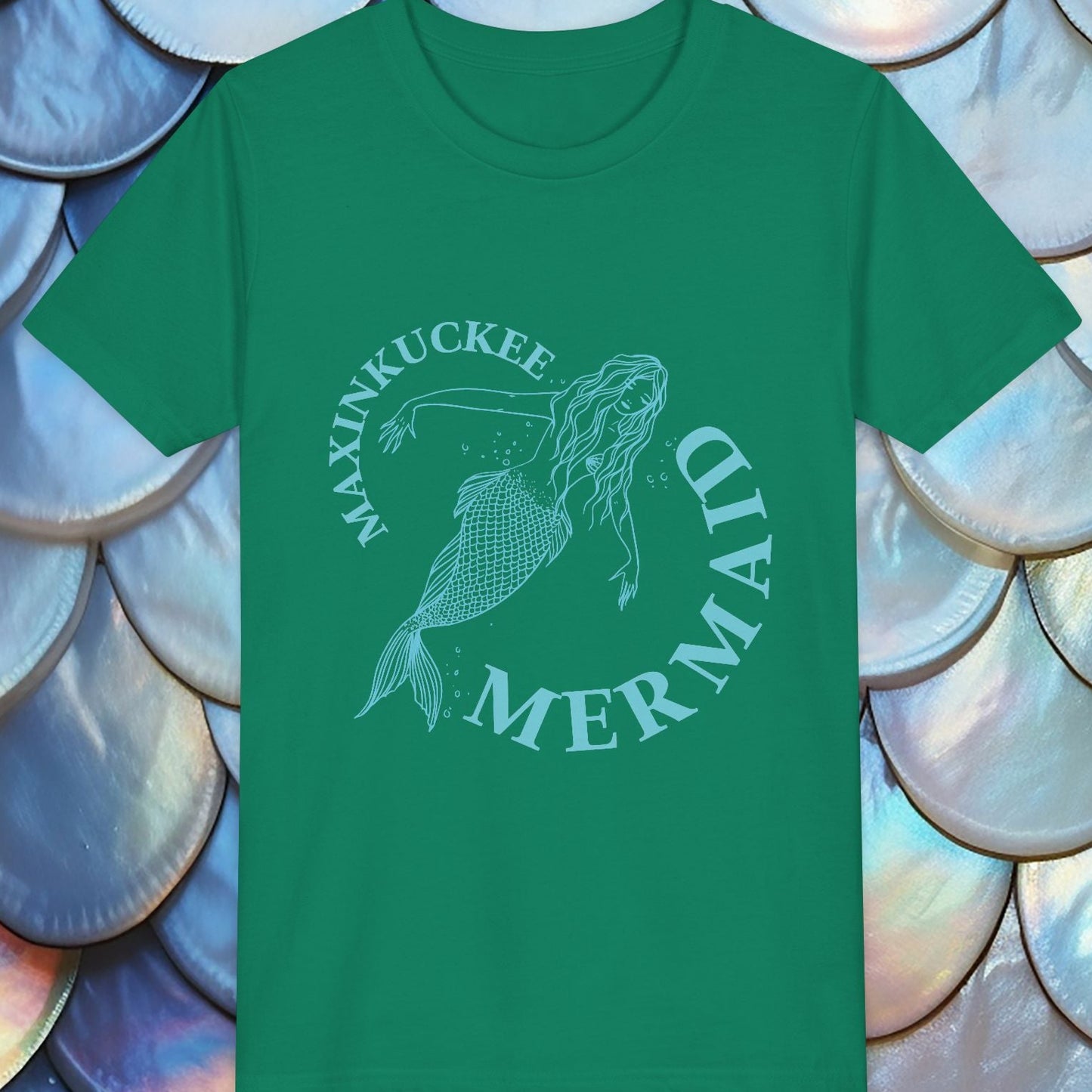 Green t-shirt with mermaid design and text on a background of shell-like patterns