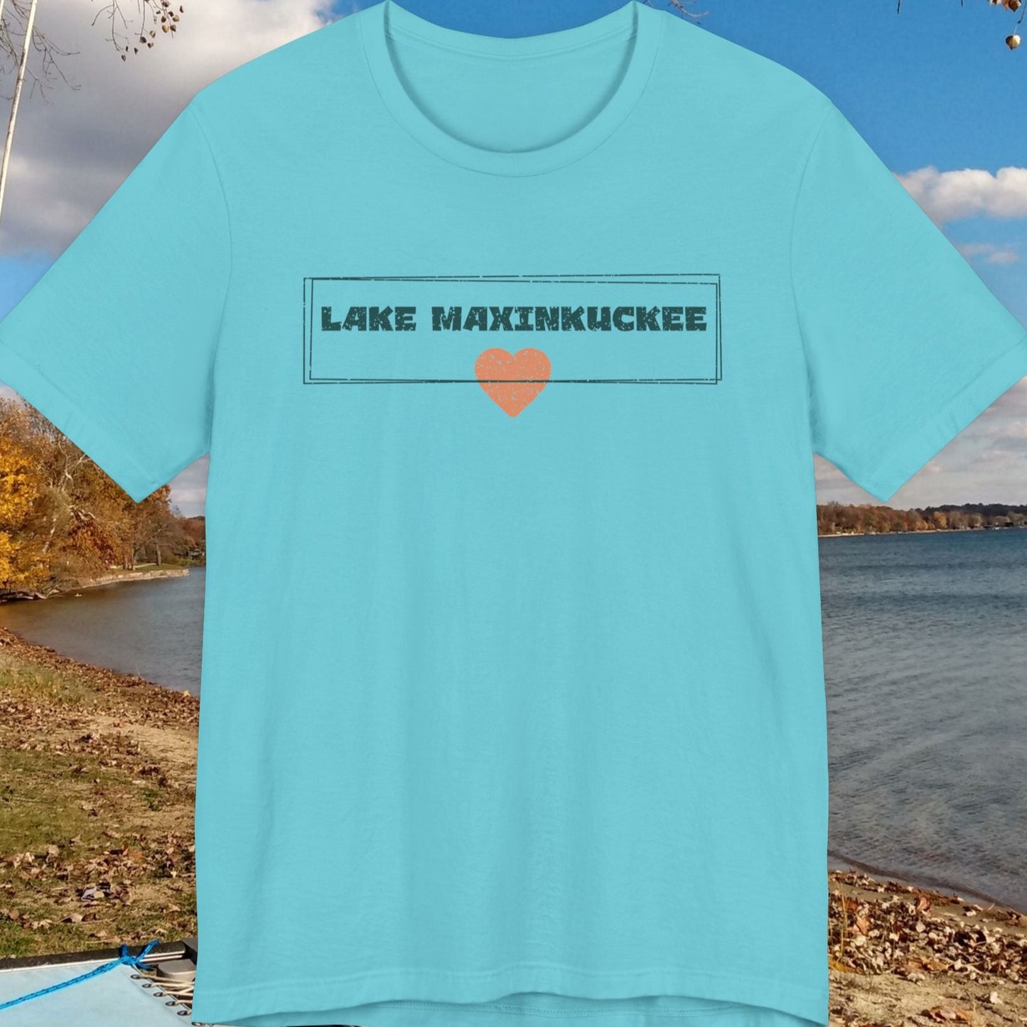 Light blue t-shirt with 'Lake Maxinkuckee' design on a lakeside background