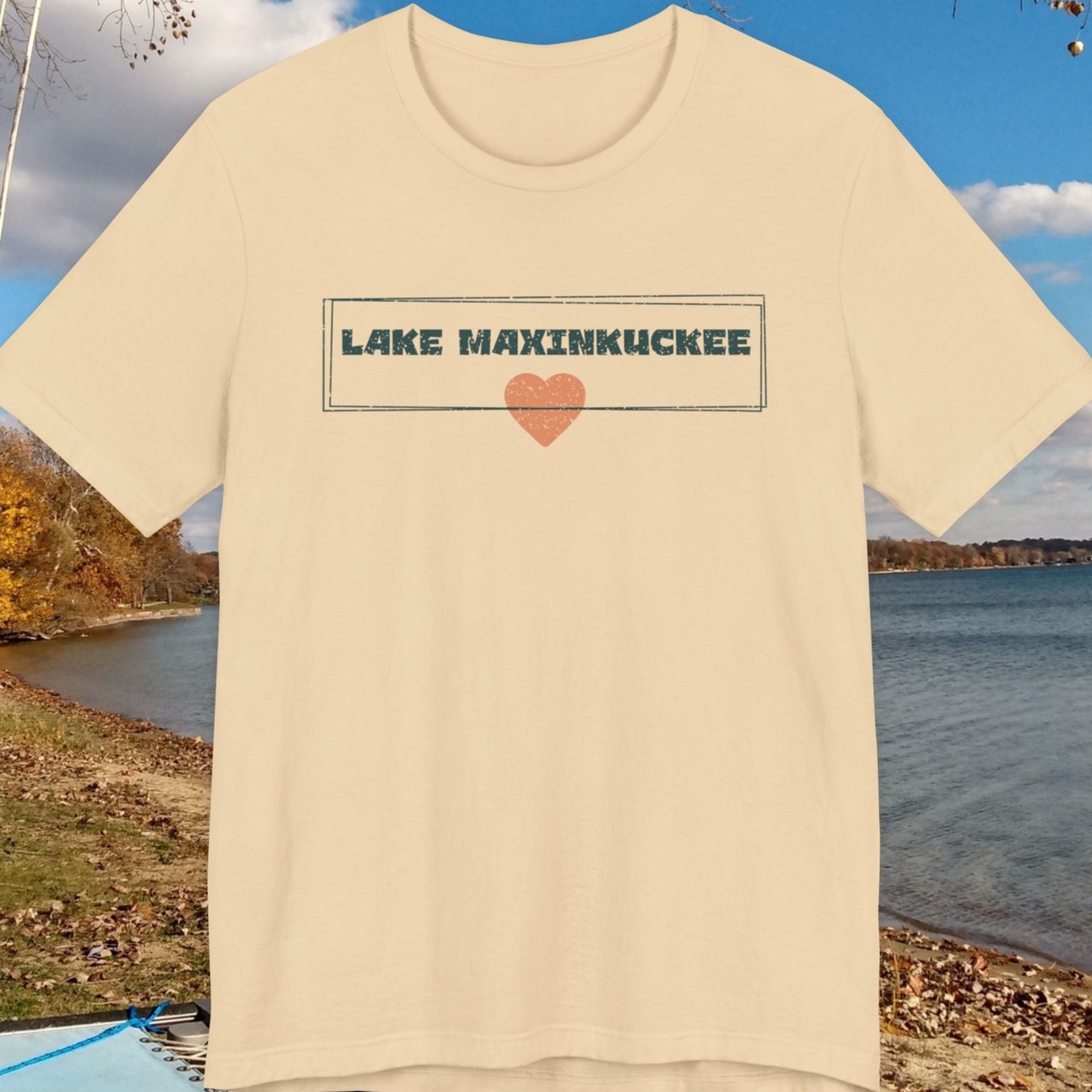 Beige t-shirt with 'Lake Maxinkuckee' design on a lakeside background