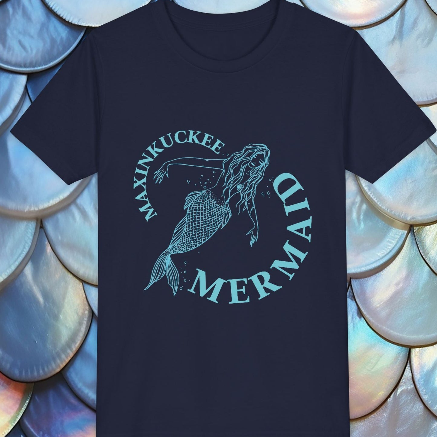 Blue t-shirt with mermaid design and text on a background of shell-like patterns