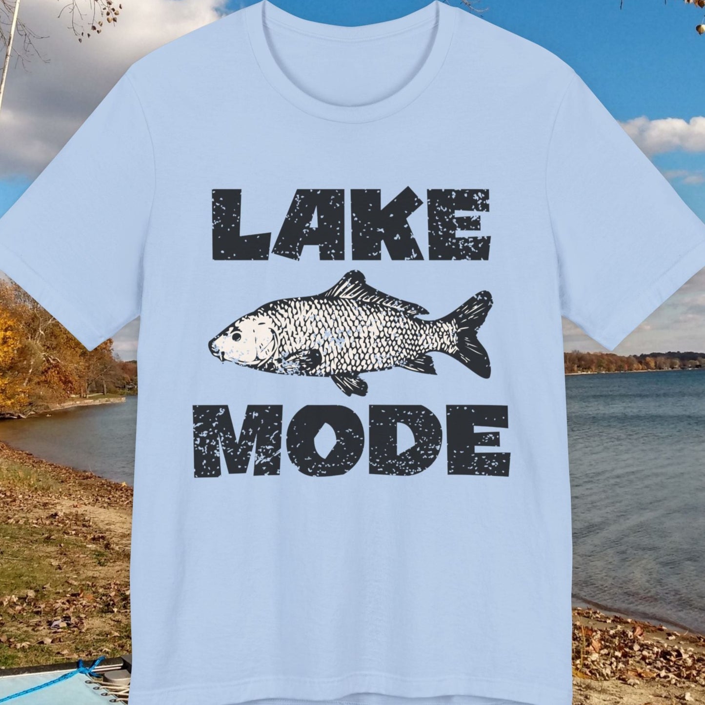 Light blue t-shirt with 'Lake Mode' graphic on a lakeside background