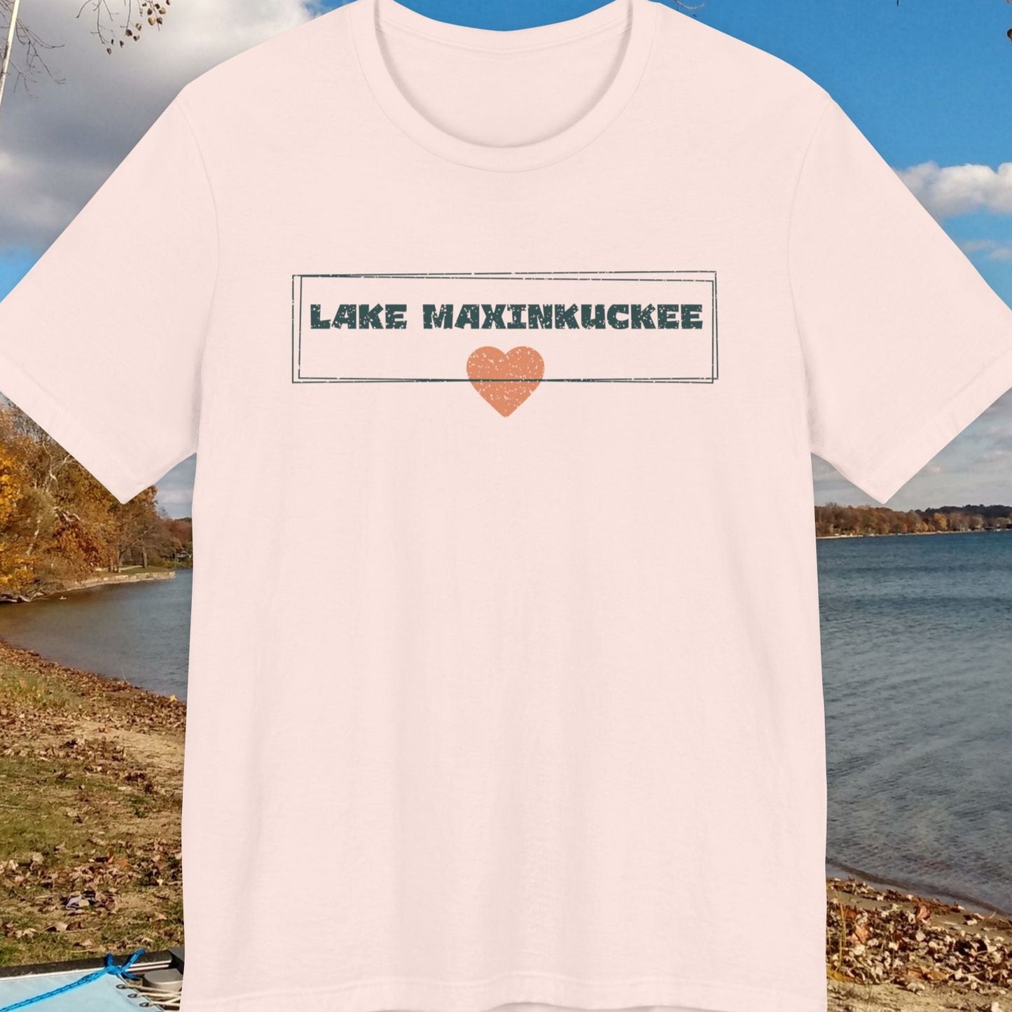 White t-shirt with 'Lake Maxinkuckee' text and heart graphic on a lakeside background