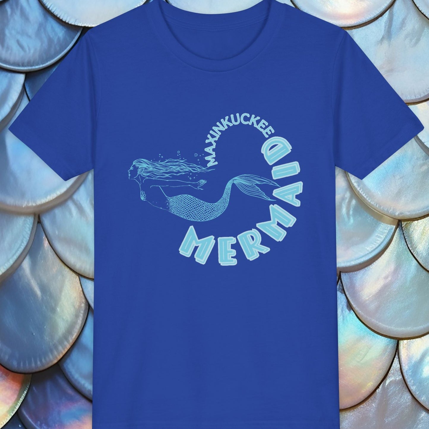 blue t-shirt with 'Maxinkuckee Mermaid' design on a background of blue and silver fish scales.