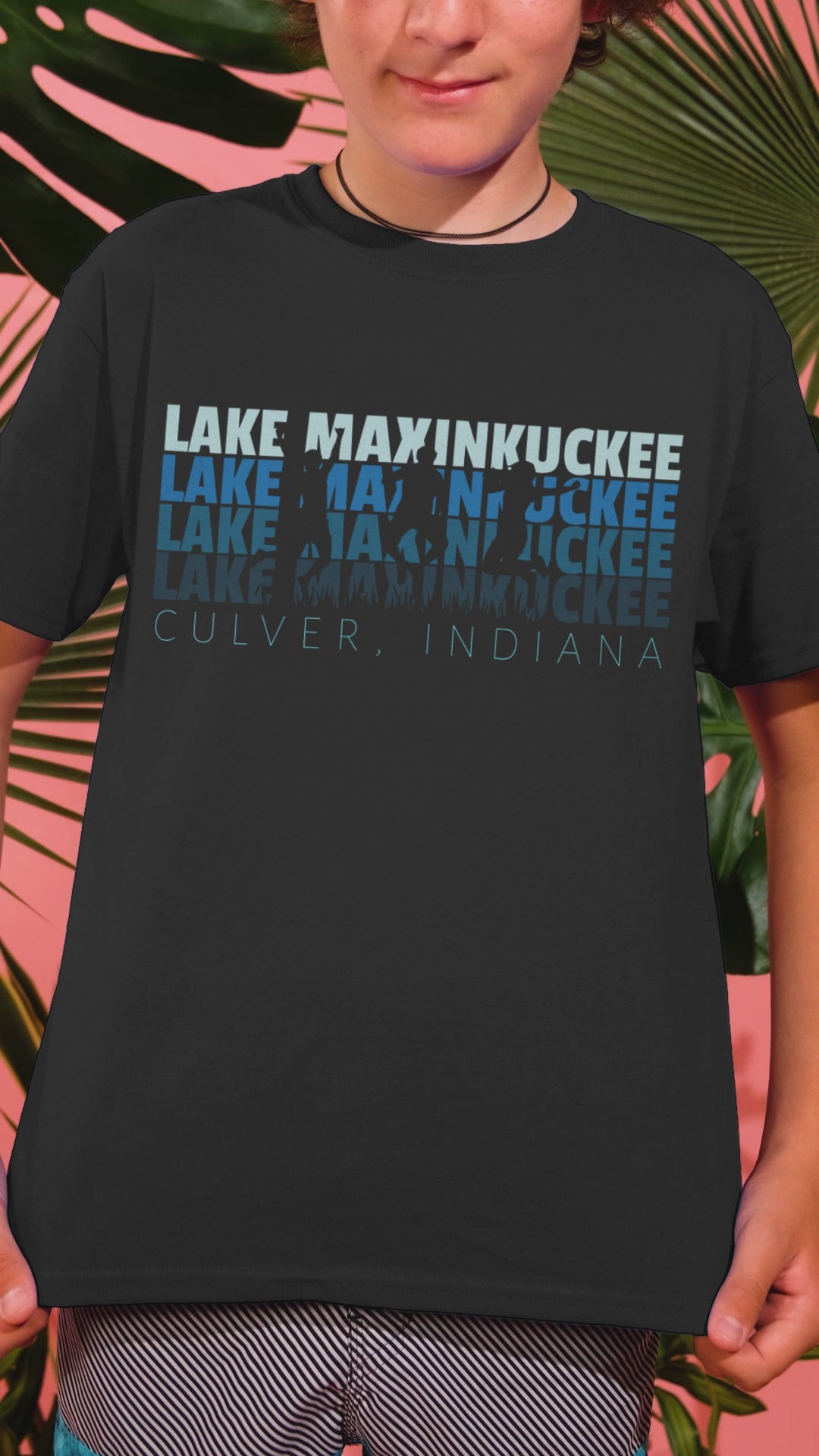 kid shirt with graphic Lake Maxinkuckee repeated 4 times horizontally from light blue to dark blue with Culver Indiana under that and an overlay of 3 jumping people in silhouette form