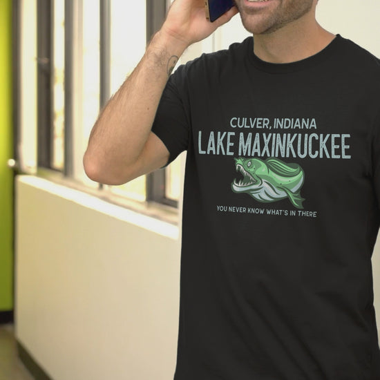 shirt with graphic of a fanged fish and text reading "Lake Maxinkuckee Culver Indiana You never know what's in there"