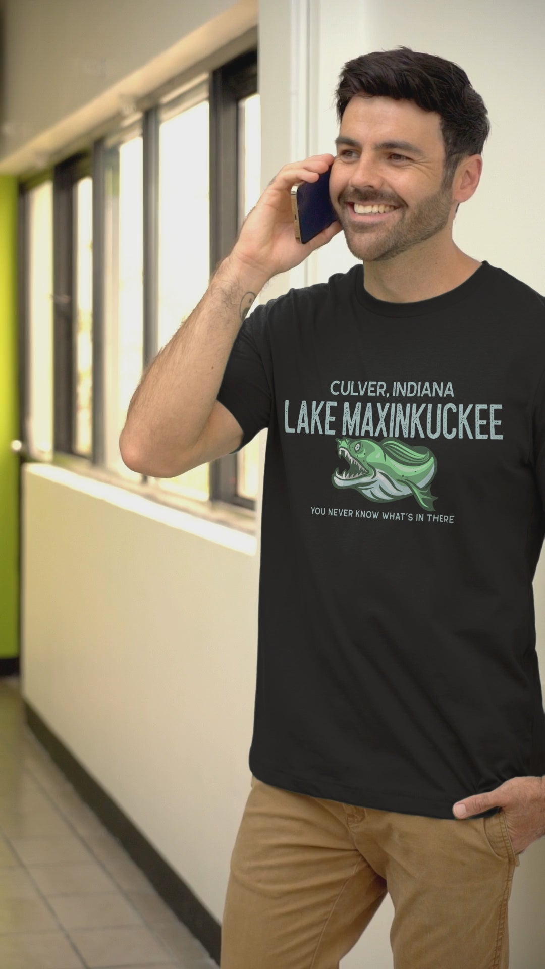 shirt with graphic of a fanged fish and text reading "Lake Maxinkuckee Culver Indiana You never know what's in there"